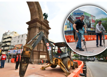 Construction Work Around a Historic Monument with an Excavator, Orange Barriers, and Workers in Red Vests Overseeing the Site. - Apoyo Regio