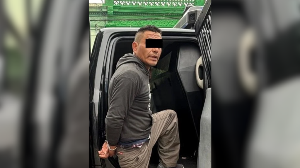 Man in a Gray Hoodie with Hands Cuffed Behind His Back Stepping into a Dark Vehicle During an Arrest Scene, Eyes Obscured by a Black Bar. - Apoyo Regio