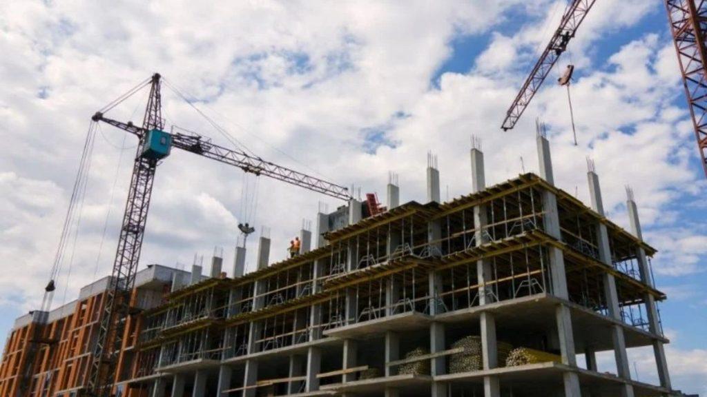Construction Site with a Multi-story Concrete Frame, Scaffolding, and Two Tall Cranes. - Apoyo Regio