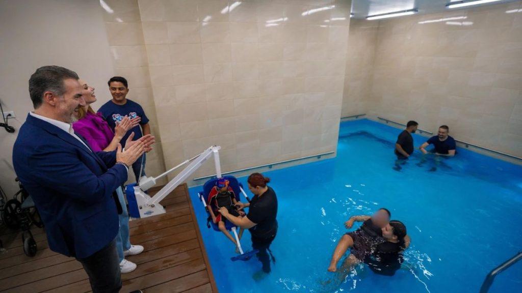 Applause from Pool Deck As a Person in a Water Wheelchair is Lowered into an Indoor Pool for Therapy/rehabilitation. - Apoyo Regio