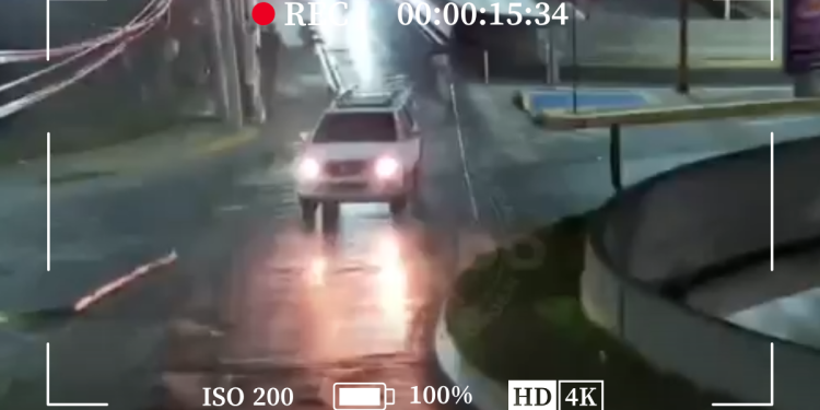 Dashcam View of a White Suv Driving Through a Wet, Rain-soaked Street at Night, Headlights On, Reflections on the Flooded Road. - Apoyo Regio