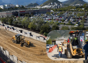 Construction site excavation with a large dirt ramp next to a Costco parking lot; heavy machinery at work and a fenced area nearby.