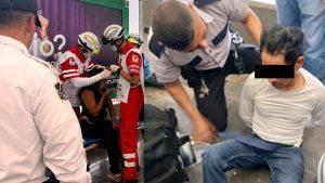 Two emergency responders in red and white uniforms treat a seated person on a stretcher; a security officer watches nearby in a public setting.