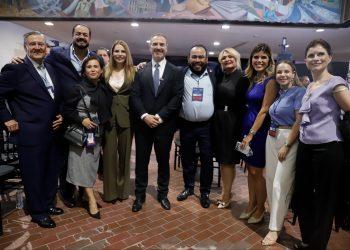 Group of Professionally Dressed People Posing for a Photo at an Indoor Event, Smiling Together. - Apoyo Regio