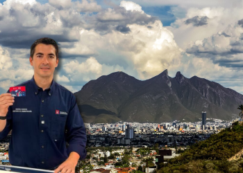 Marcelosegovia-red-ciudadana-pan - Apoyo Regio Man in a Navy Shirt Holds Up a Red Card in Front of a Cityscape with a Mountain Range and Cloudy Sky in the Background. - Apoyo Regio