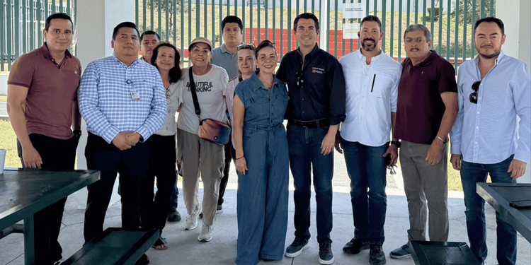 Group of Eleven Adults Standing Together Outdoors, Posing for a Casual Team Photo Under a Pavilion. - Apoyo Regio