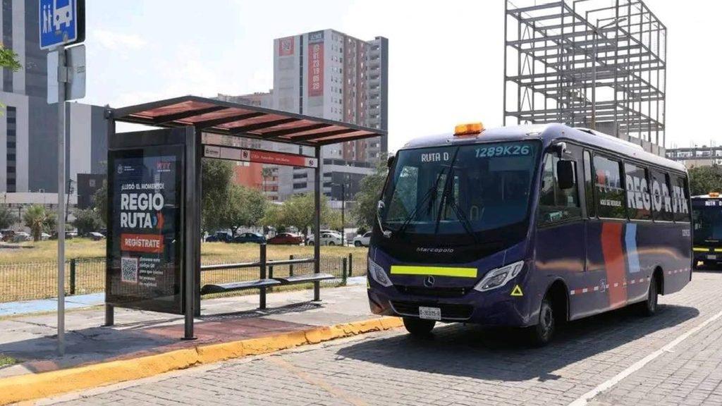 Blue Passenger Bus Branded Regio Routa at a Curbside Bus Stop with a Shelter in a Sunny Urban Street Setting. - Apoyo Regio