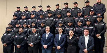 Group of Uniformed Personnel in Matching Black Jackets and Caps Posing for a Photo Indoors. - Apoyo Regio