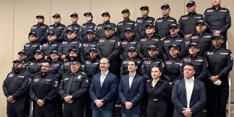 Group of Uniformed Personnel in Matching Black Jackets and Caps Posing for a Photo Indoors. - Apoyo Regio