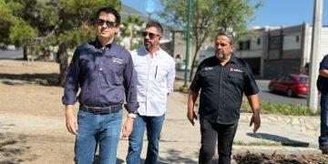 Three Men Wearing Button-down Shirts Walk on a Sunny Sidewalk, Looking Ahead with Serious Expressions. - Apoyo Regio
